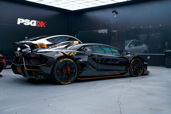 Black sports car with aerodynamic design in a sleek modern garage environment. Voitures 4K