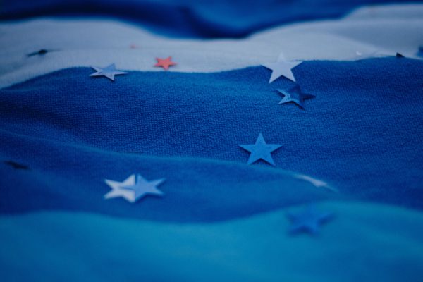 Blue fabric with scattered star shapes creating abstract visual patterns. Espace 4K