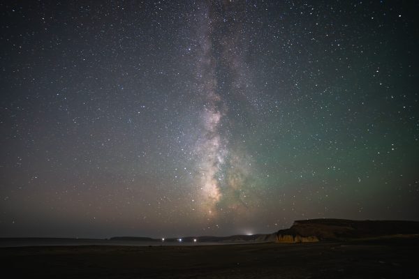 Breathtaking night sky view of the Milky Way rising over a serene coastal landscape with stars shining bright. Espace 4K
