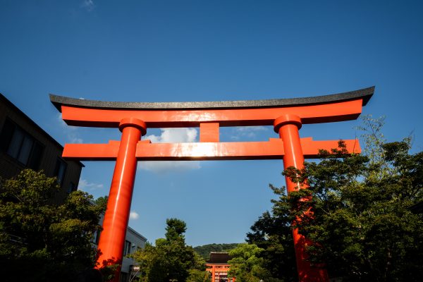 Breathtaking view of a traditional red Torii gate under blue skies in Kyoto, Japan. Anime 4K