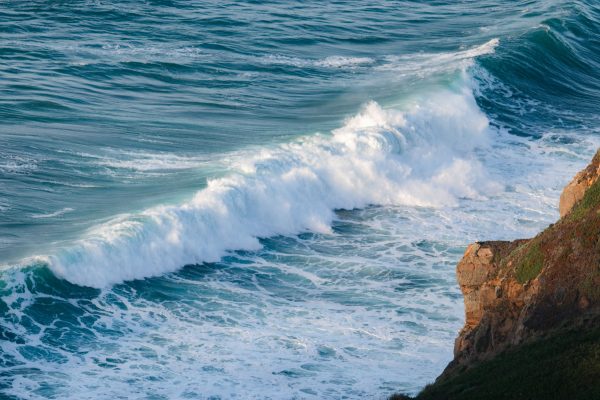 Breathtaking view of powerful ocean waves crashing against a rocky shoreline, showcasing nature's beauty. Nature 4K
