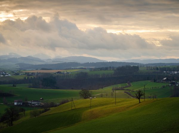 Breathtaking view of rolling hills and fields under a dramatic sunset sky. Nature 4K