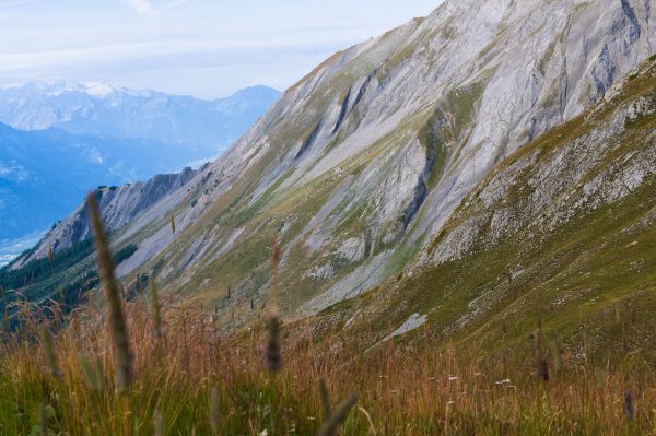 Breathtaking view of the Swiss Alps showcasing rugged mountains and lush meadows under a clear sky. Nature 4K