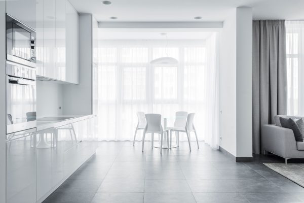 Bright minimalist dining area with white furniture and modern kitchen design. Minimaliste 4K