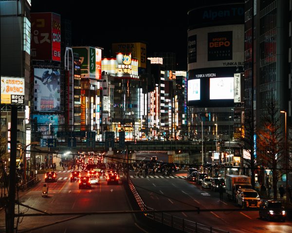 Bright urban scene in Shinjuku, Tokyo, filled with neon lights and bustling traffic at night. Voitures 4K