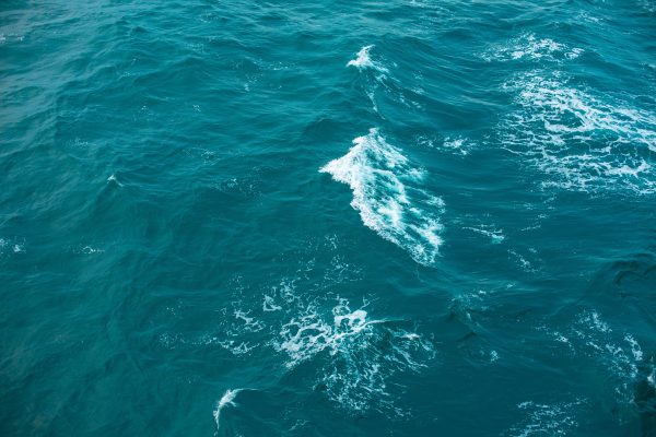 Captivating aerial view of turquoise ocean waves with white ripples. Nature 4K