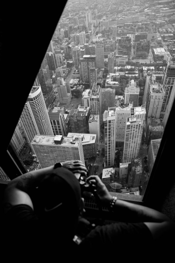 Captivating black and white aerial photo capturing a person photographing skyscrapers. Mobile 4K
