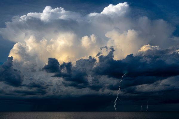 Captivating image of a thunderstorm with lightning strikes over the ocean, capturing nature's raw power. Dark 4K