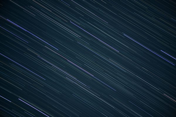 Captivating long exposure of star trails creating streaks in the night sky. Espace 4K