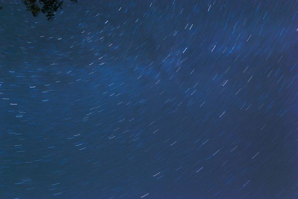 Captivating long exposure of star trails forming a swirling pattern in the night sky. Espace 4K