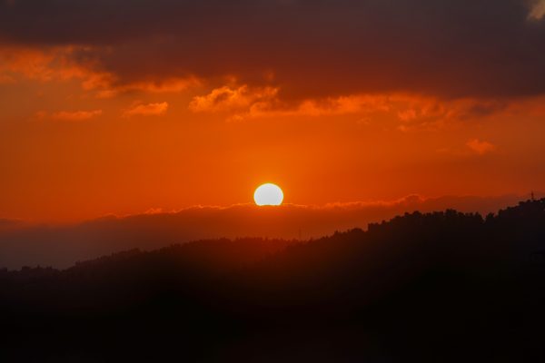 Captivating orange sunset with silhouetted hills and vibrant clouds in a serene atmosphere. Nature 4K