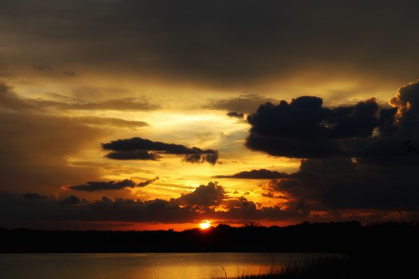 Captivating sunset in Yucatan, Mexico, with vibrant clouds over a calm lake. Dark 4K