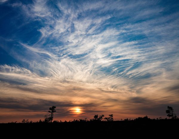 Captivating sunset over a silhouette landscape with striking cloud formations and a vivid sky. Nature 4K
