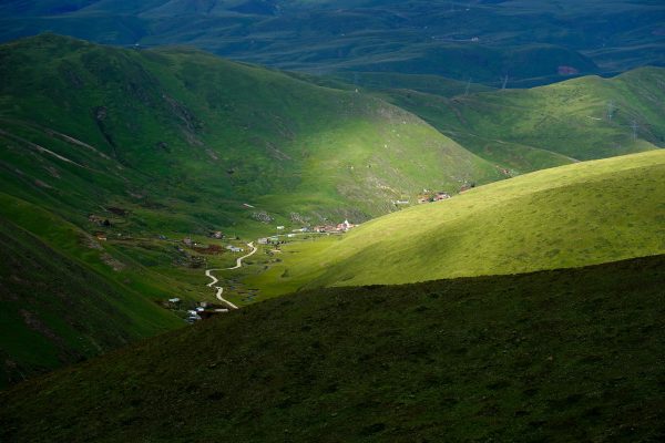 Captivating view of a lush green valley with sunlight and shadows creating a serene landscape. Nature 4K
