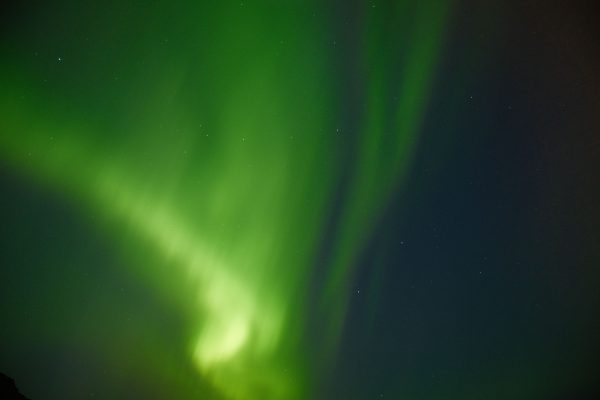 Captivating view of the Northern Lights dancing across Iceland's night sky, showcasing nature's vivid green hues. Espace 4K