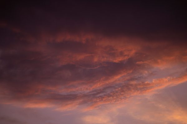 Capture of a dramatic sunset sky with vibrant and dark cloud formations. Dark 4K