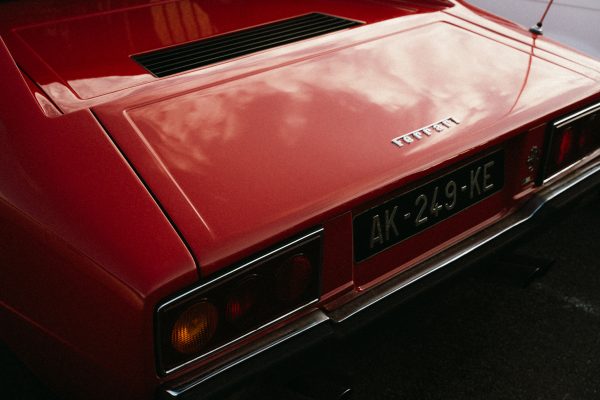 Close-up of a classic red Ferrari car showcasing its sleek design in Montigny-le-Bretonneux. Voitures 4K