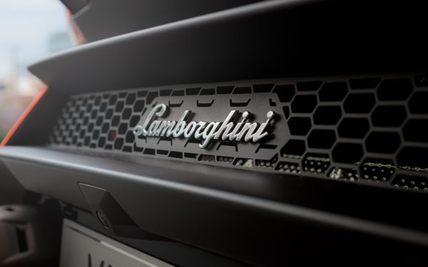 Close-up of a Lamborghini Huracan grille showcasing the luxury sports car emblem. Voitures 4K