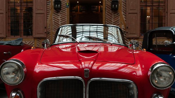 Close-up of a vintage red car parked indoors, showcasing elegant design. Voitures 4K