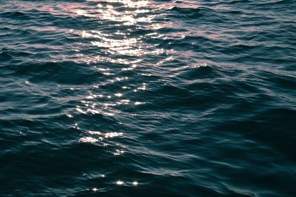 Close-up of deep blue ocean waves with sunlight reflecting, creating a serene and textured water surface. Nature 4K