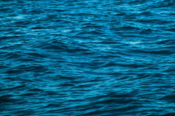 Close-up of the ocean's surface highlighting calm waves and blue water texture. Nature 4K