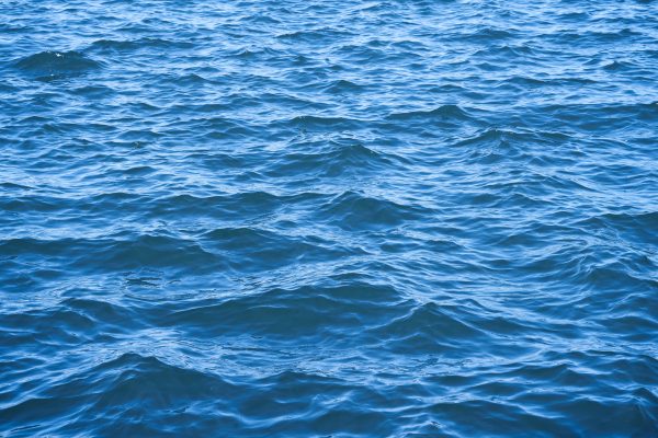 Close-up of wavy blue ocean surface on a sunlit day, capturing serene natural beauty. Nature 4K