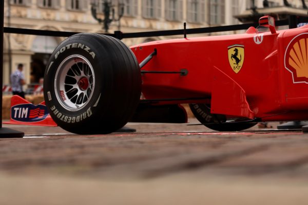 Close-up shot of a red Formula 1 racing car with visible brand logos and Bridgestone tire. Voitures 4K