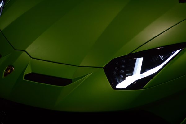 Close-up view of a green Lamborghini showcasing its sleek design and vibrant headlights. Voitures 4K