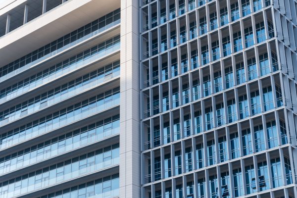 Close-up view of a modern highrise building with glass facade and geometric design elements. Architecture 4K