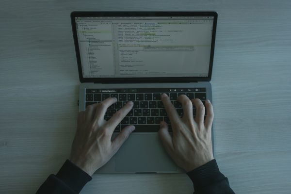 Close-up view of a programmer coding on a laptop, showcasing modern software development.