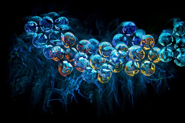 Colorful abstract neon jellyfish-like shapes with a futuristic and illuminated fractal design on a black background. Abstrait 4K