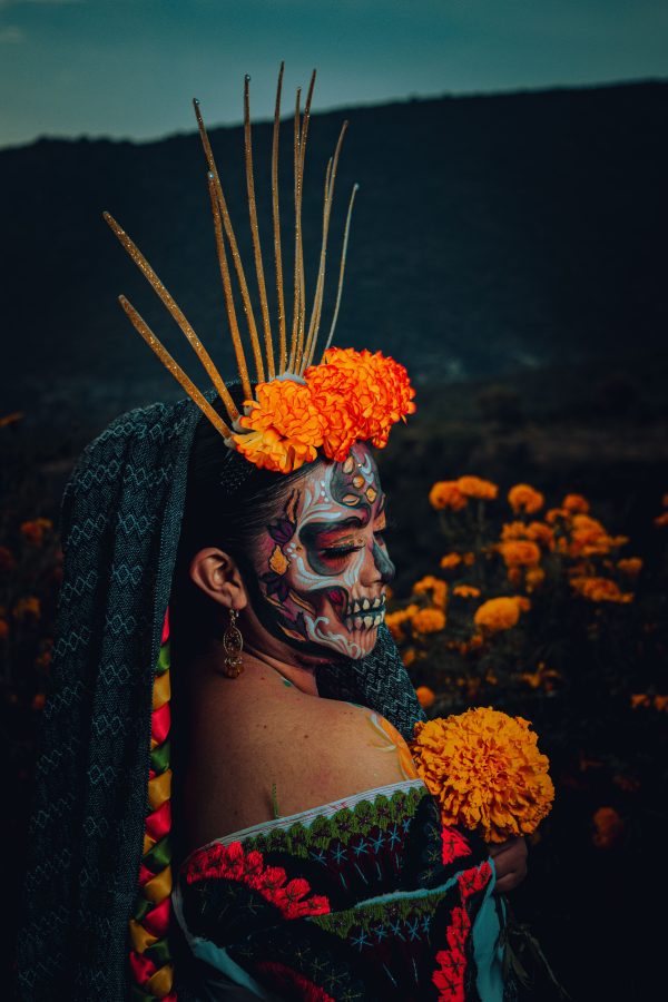 Colorful portrait of a woman at Day of the Dead celebration with face paint and marigold flowers. Mobile 4K