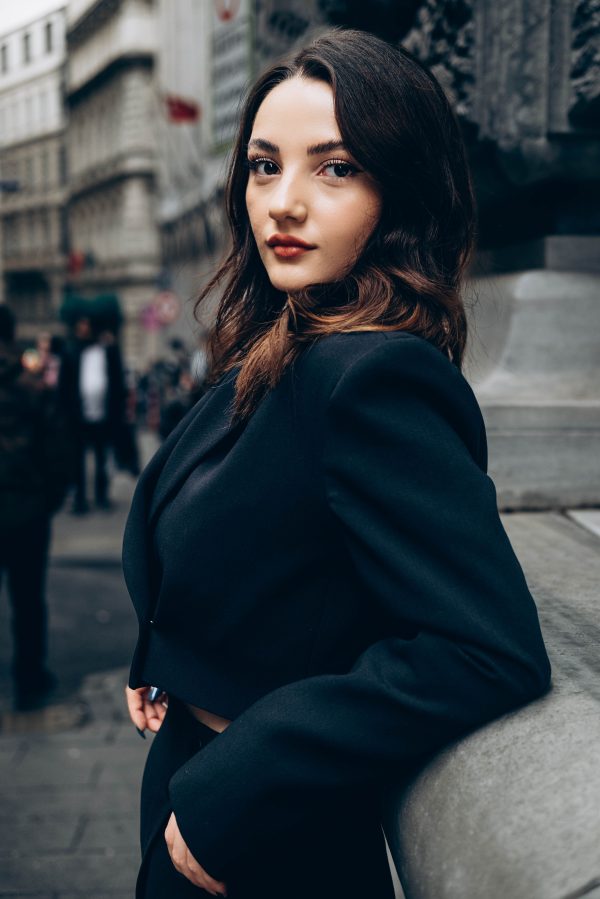 Confident woman in elegant black jacket posing in the streets of Türkiye. Urban fashion photography. Mobile 4K