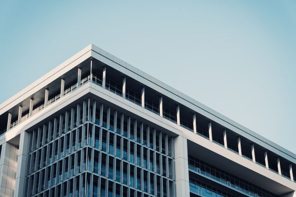 Contemporary office building with a futuristic glass facade reflecting the sky. Architecture 4K