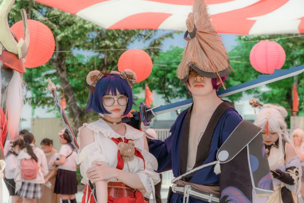 Cosplayers in detailed costumes at an outdoor event with lanterns and vibrant decor, capturing a festive atmosphere. Manga 4K