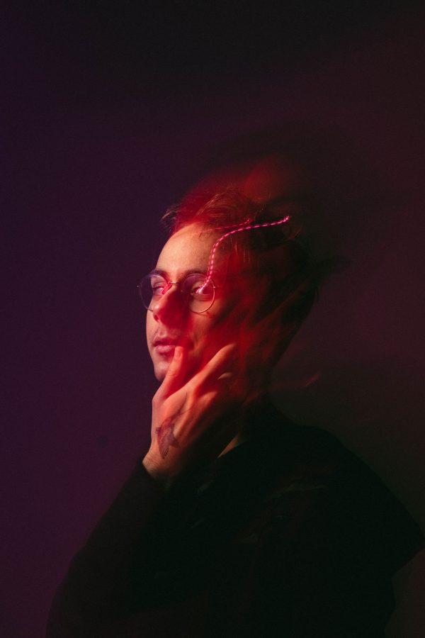 Creative studio portrait of a person with red lighting and dynamic motion blur. Mobile 4K