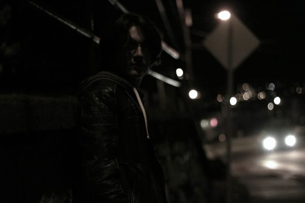 Dark and atmospheric street scene featuring a person in urban setting at night. Voitures 4K