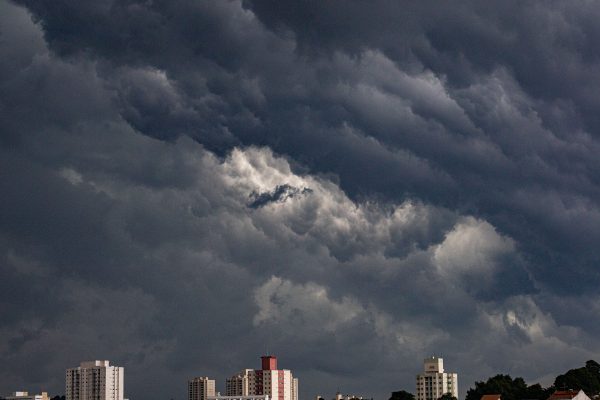 Dark dramatic clouds gathering over urban buildings, hinting at an approaching storm. Dark 4K