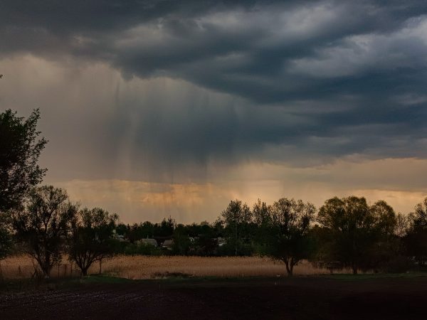 Dark storm clouds gather over a rural field, hinting at approaching rain. Captured in detail, this scene evokes a sense of impending weather change. Dark 4K