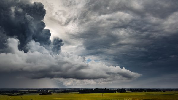 Dark storm clouds loom over the green fields of Poland, capturing nature's power. Dark 4K