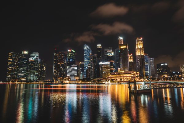 Dazzling night view of Singapore's illuminated skyline reflecting on water, showcasing modern skyscrapers. Architecture 4K
