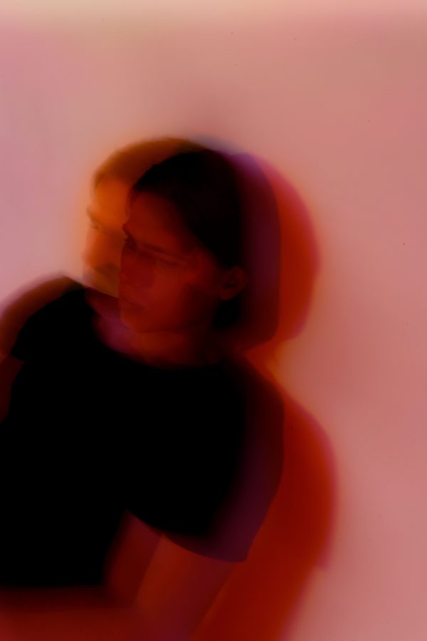 Defocused anonymous young anxious male with split personality standing near wall with shade in twilight while looking away Mobile 4K