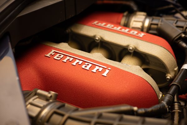 Detailed close-up of a Ferrari engine showcasing luxury and performance. Voitures 4K