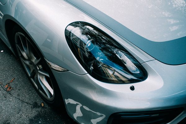 Detailed close-up of a parked silver car showcasing its shiny reflective headlight and modern design. Voitures 4K
