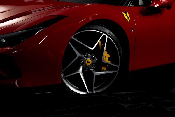 Detailed shot of a luxury sports car wheel with visible logo, showcasing sleek design and elegance. Voitures 4K