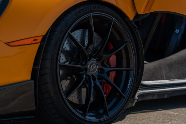 Detailed view of a black sports car wheel with carbon ceramic brakes in Illinois. Voitures 4K