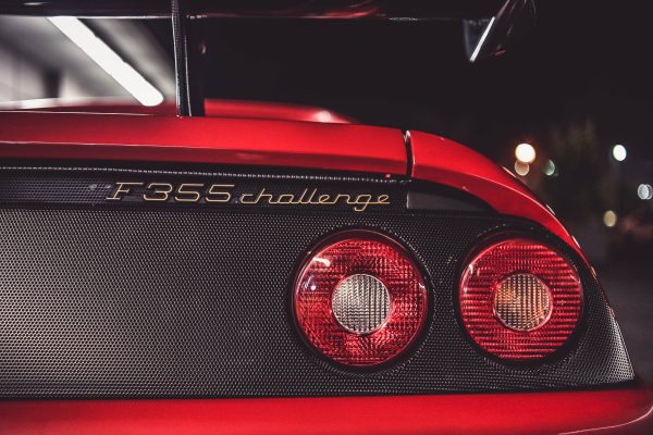 Detailed view of a Ferrari F355 Challenge taillight showcasing luxury design at night. Voitures 4K