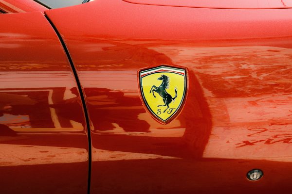 Detailed view of a sleek red sports car with an eye-catching emblem. Voitures 4K