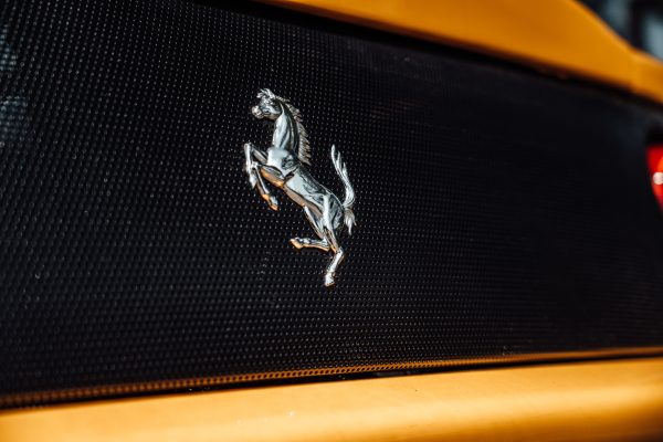 Detailed view of a yellow Ferrari's iconic prancing horse emblem on the grill. Voitures 4K