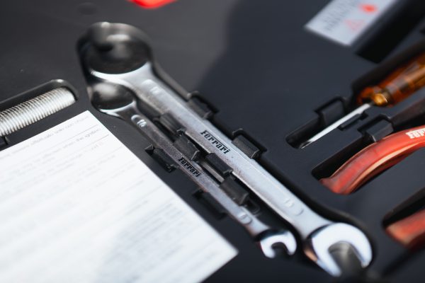 Detailed view of Ferrari-branded wrenches in a toolkit box, highlighting sports car maintenance essentials. Voitures 4K